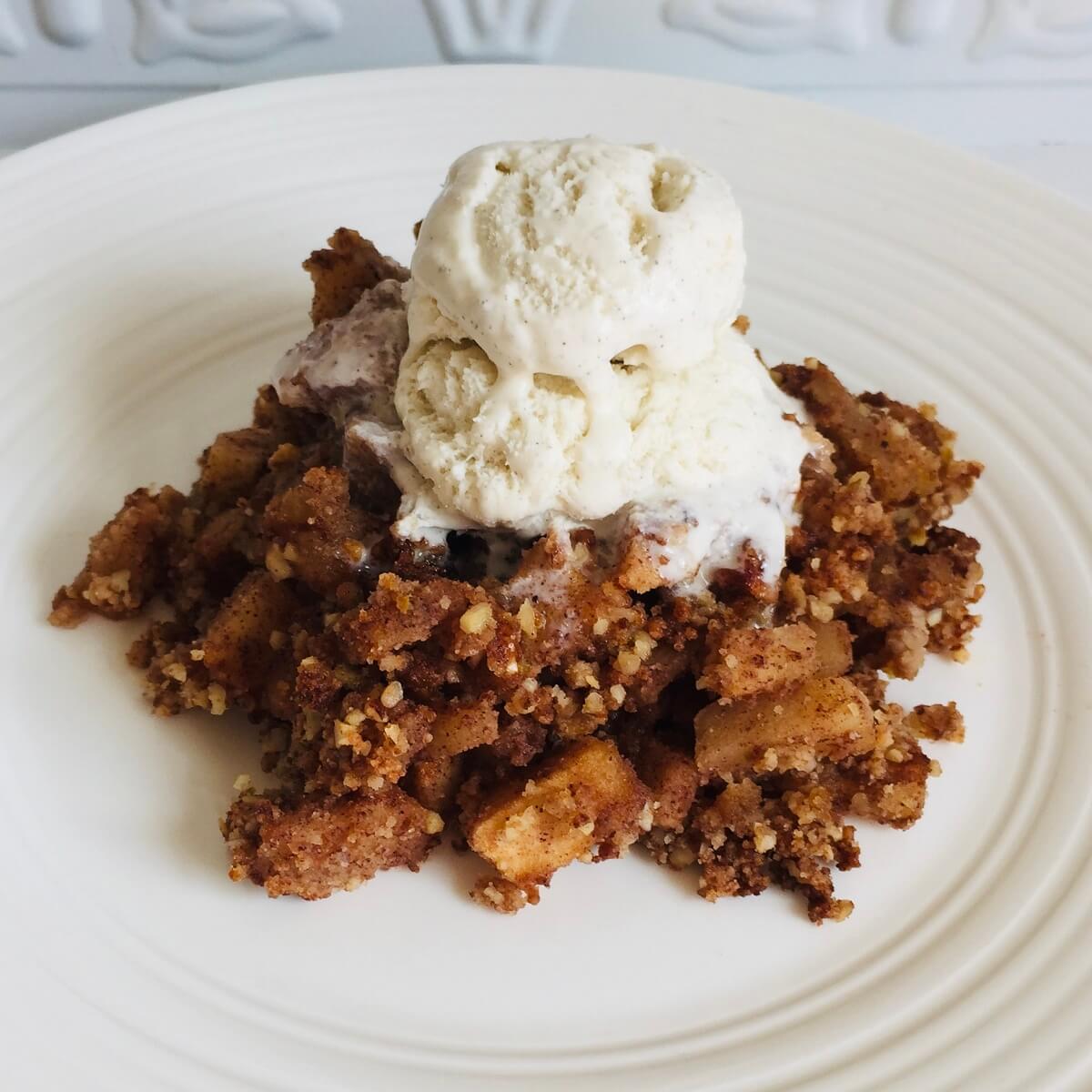 Vegan apple crumble on a white plate.