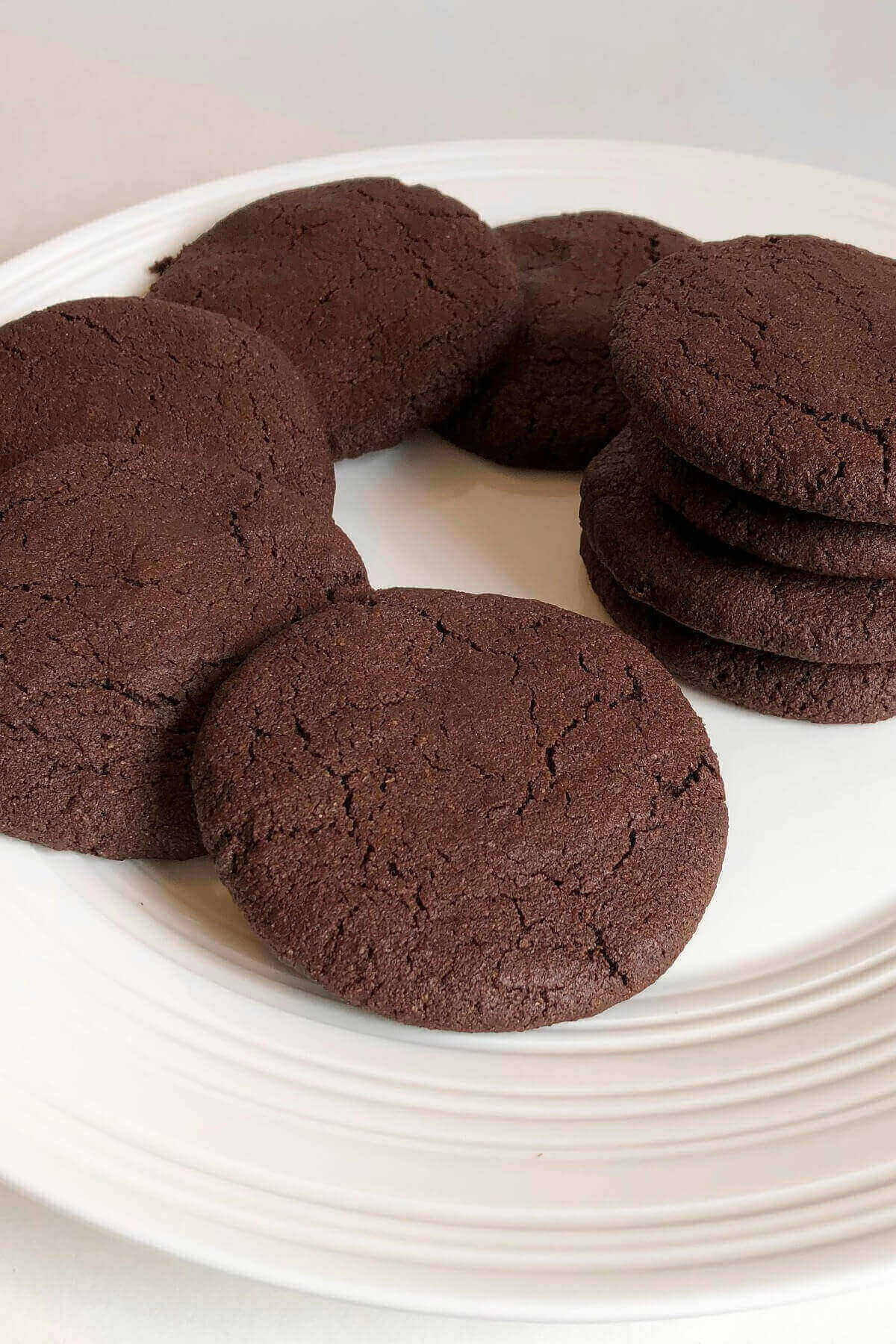 Chocolate spelt cookies displayed on a white plate.