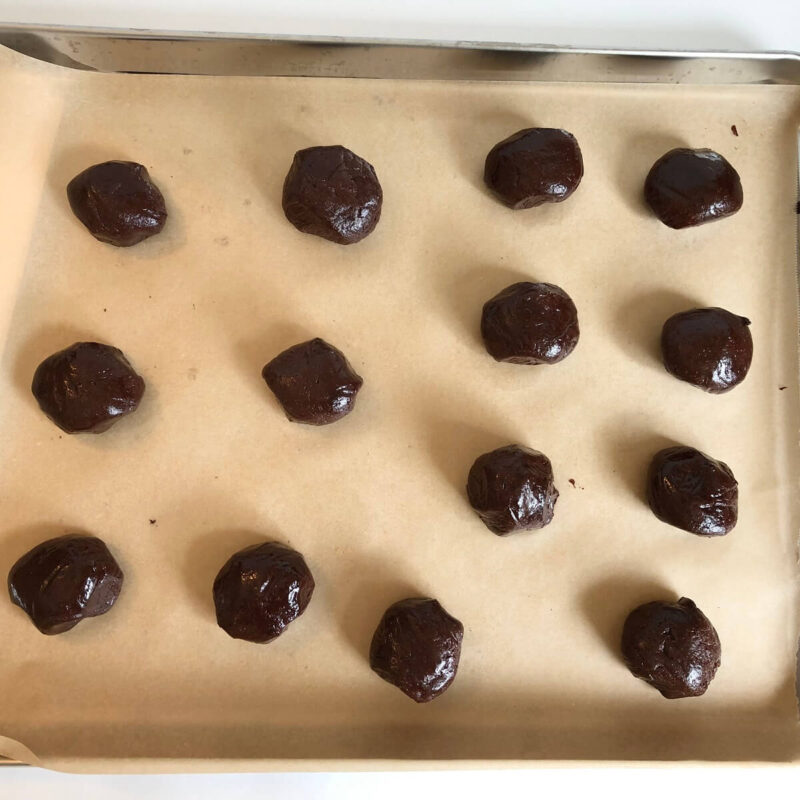 Spelt cookie dough balls on a sheet pan.