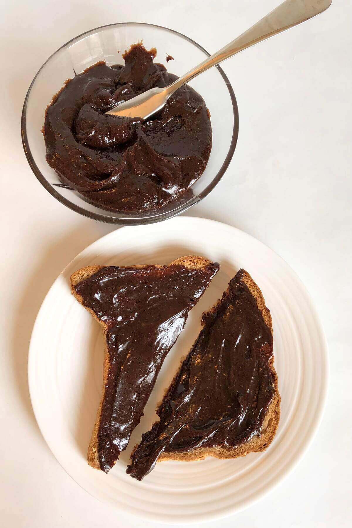 Toast with chocolate spread next to a glass bowl.