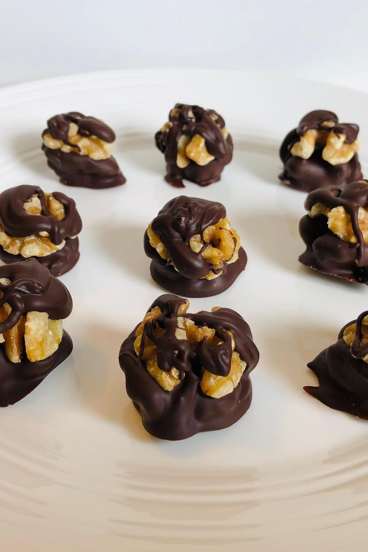 Chocolate covered walnuts displayed on a plate.