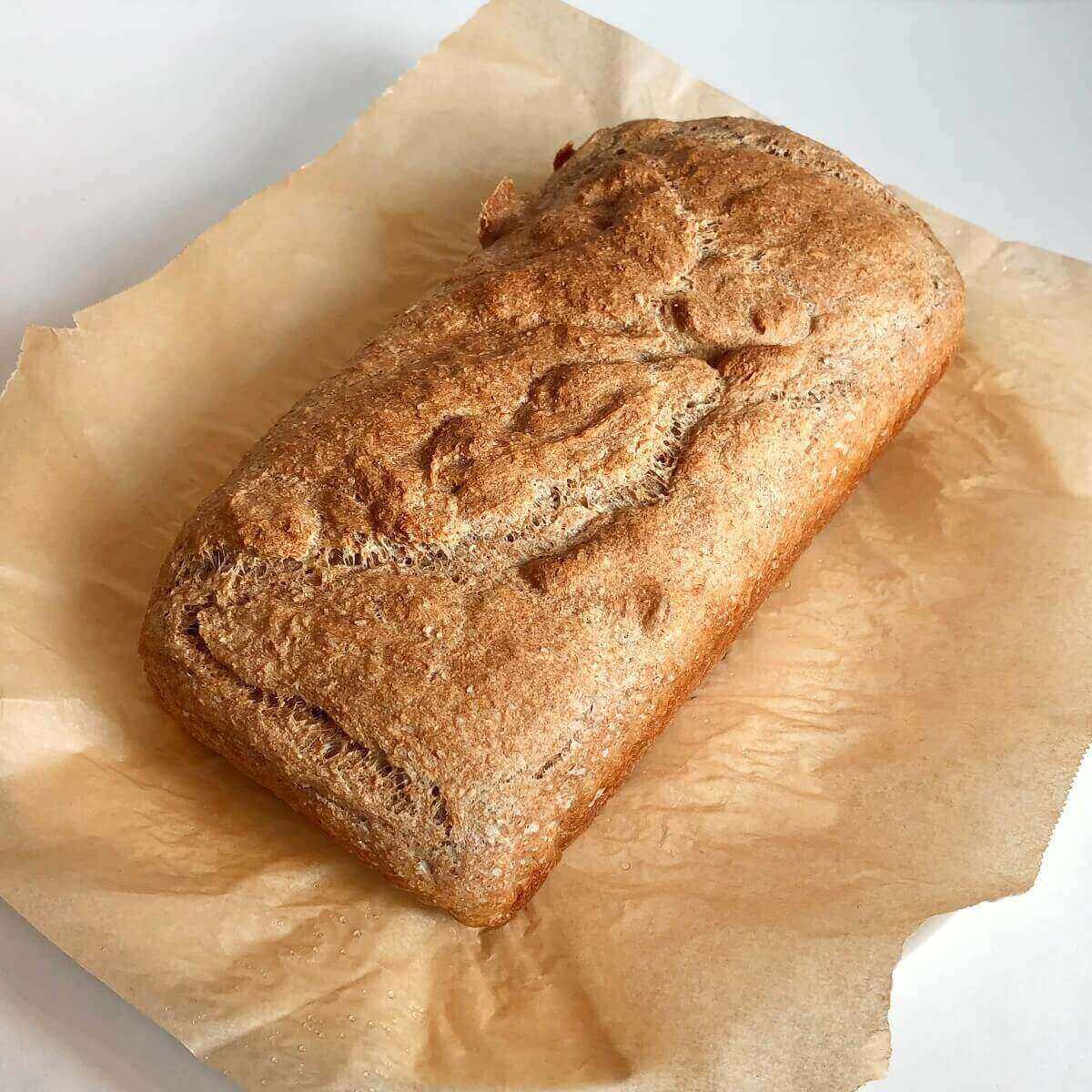 A loaf of bread on a piece of parchment paper.