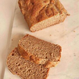 A loaf of wheat bread with two slices cut off.