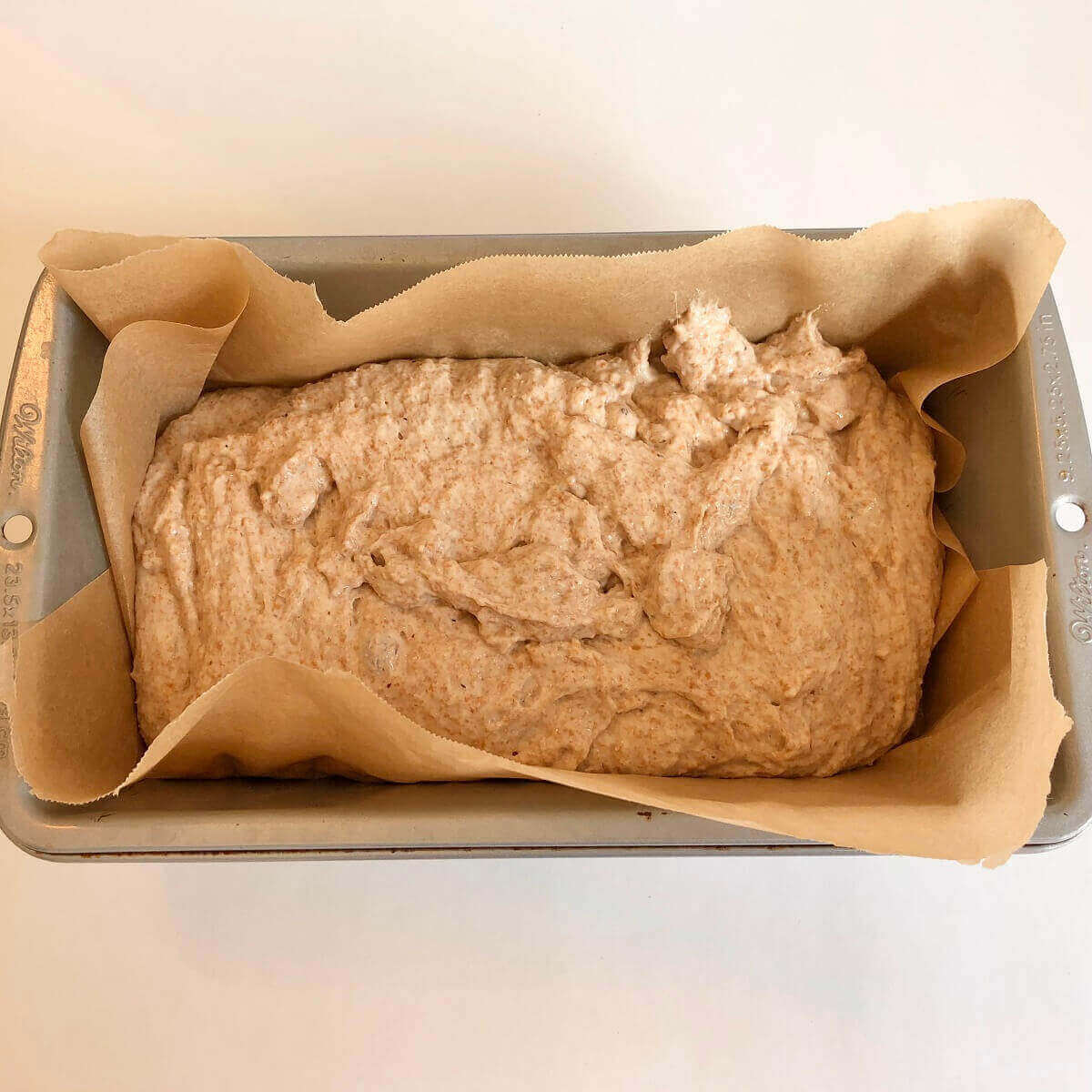 Raw bread dough in a loaf pan.