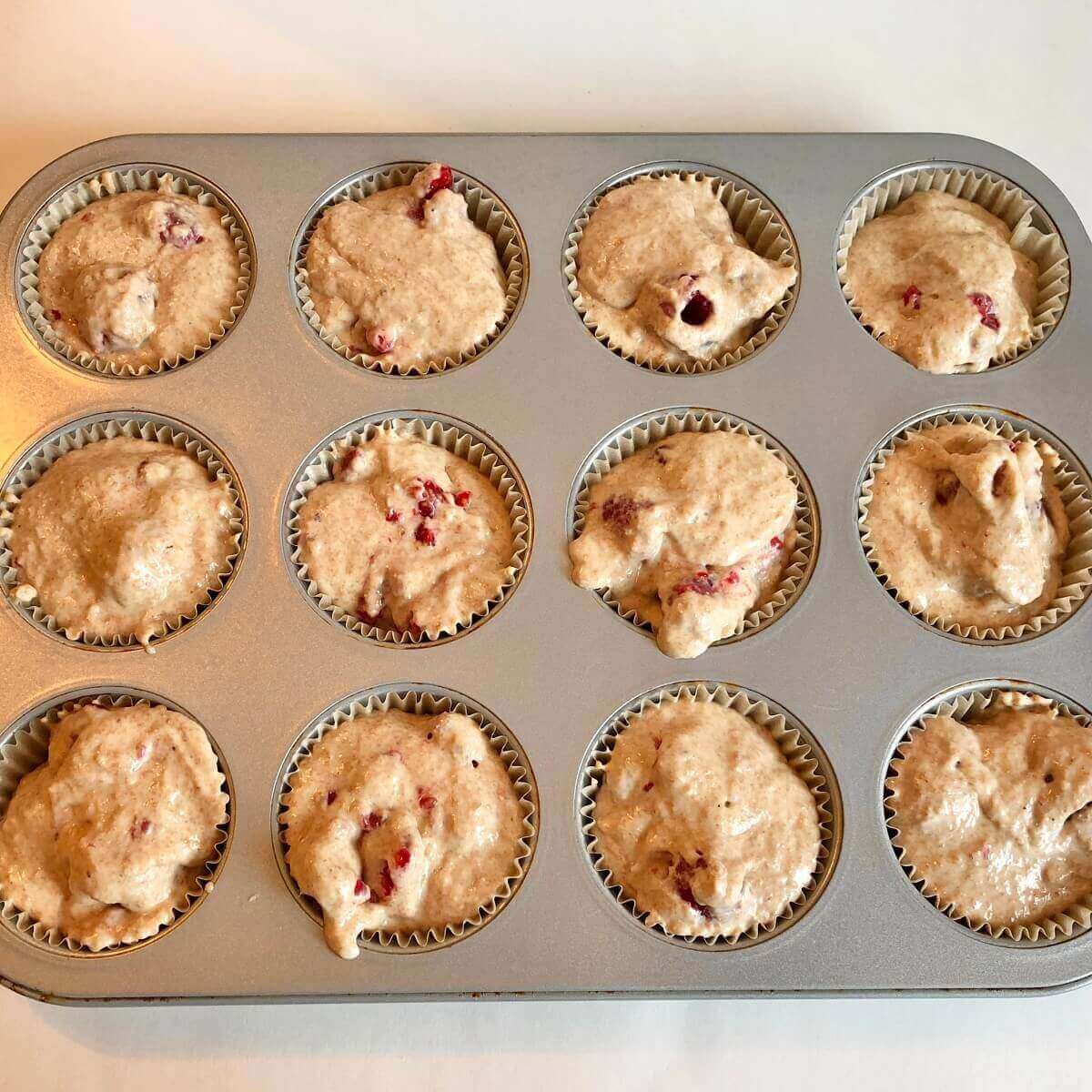 Raw muffins in a metal pan.