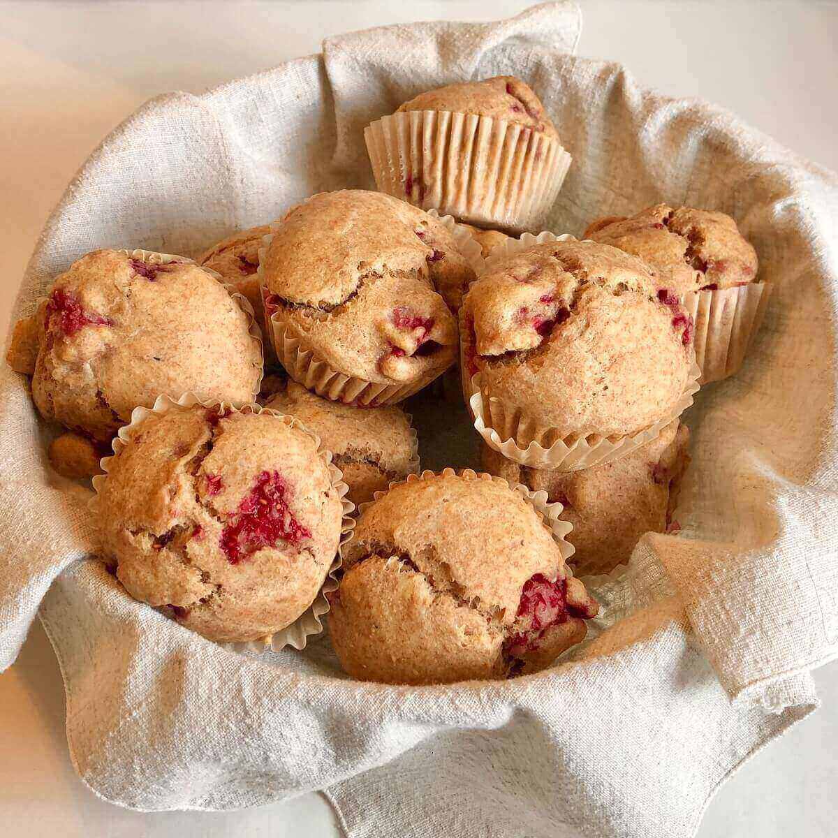 Raspberry muffins piled in a basket.
