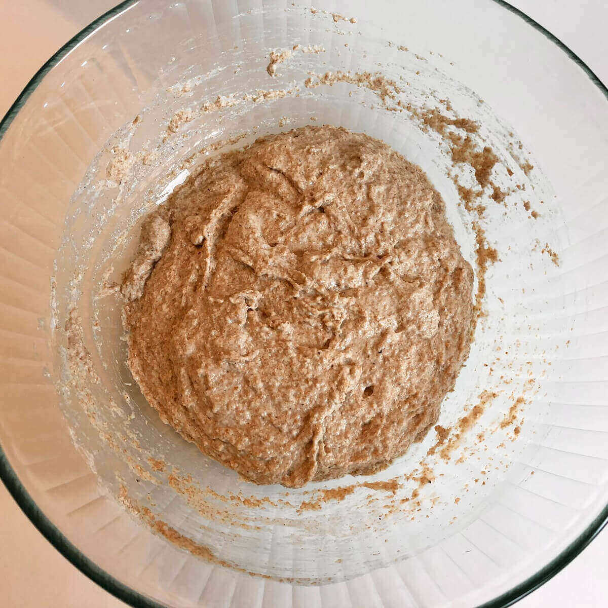 Wheat bread dough in a glass bowl.