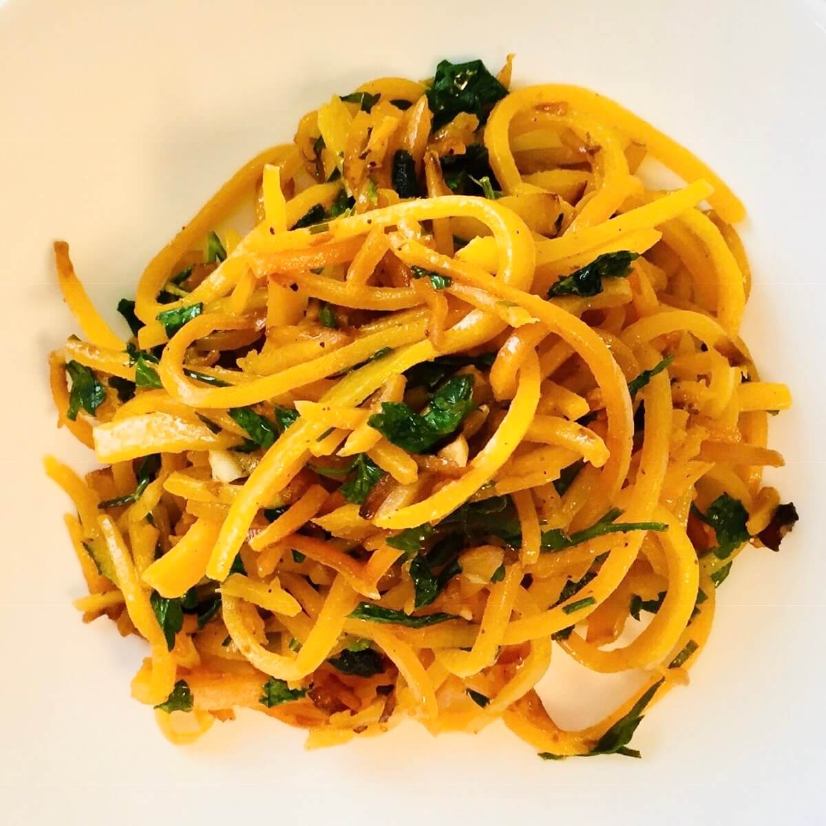 Butternut squash noodles in a white bowl.