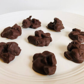 Chocolate covered dried cherries on a white plate.