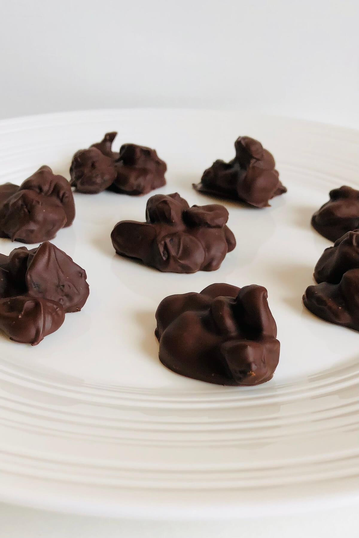 Chocolate dipped cherries on a plate.