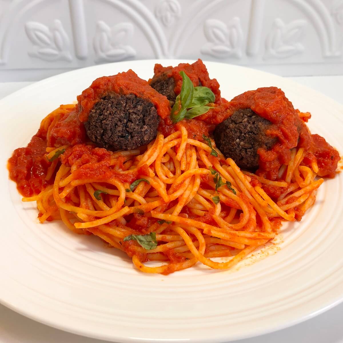 Walnut mushroom meatballs and pasta on a white plate.