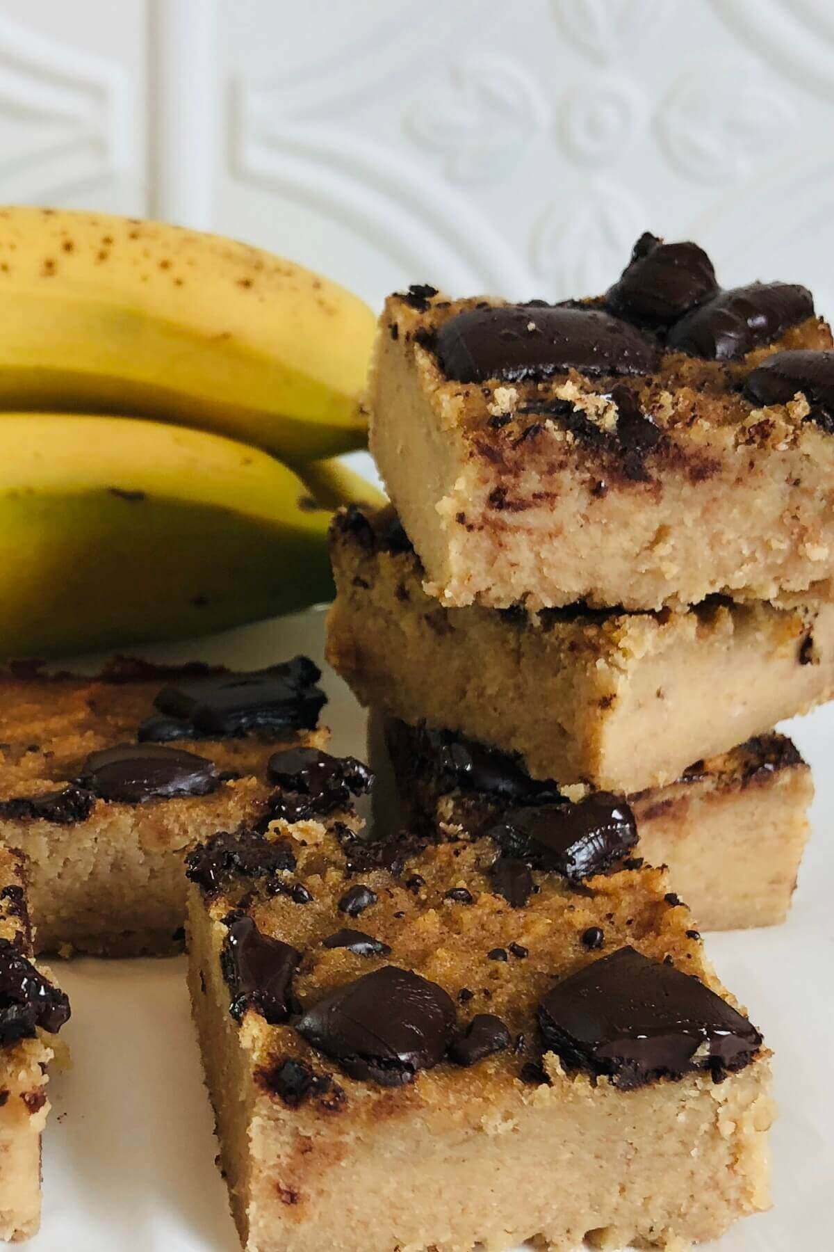 Blondies stacked next to some bananas.