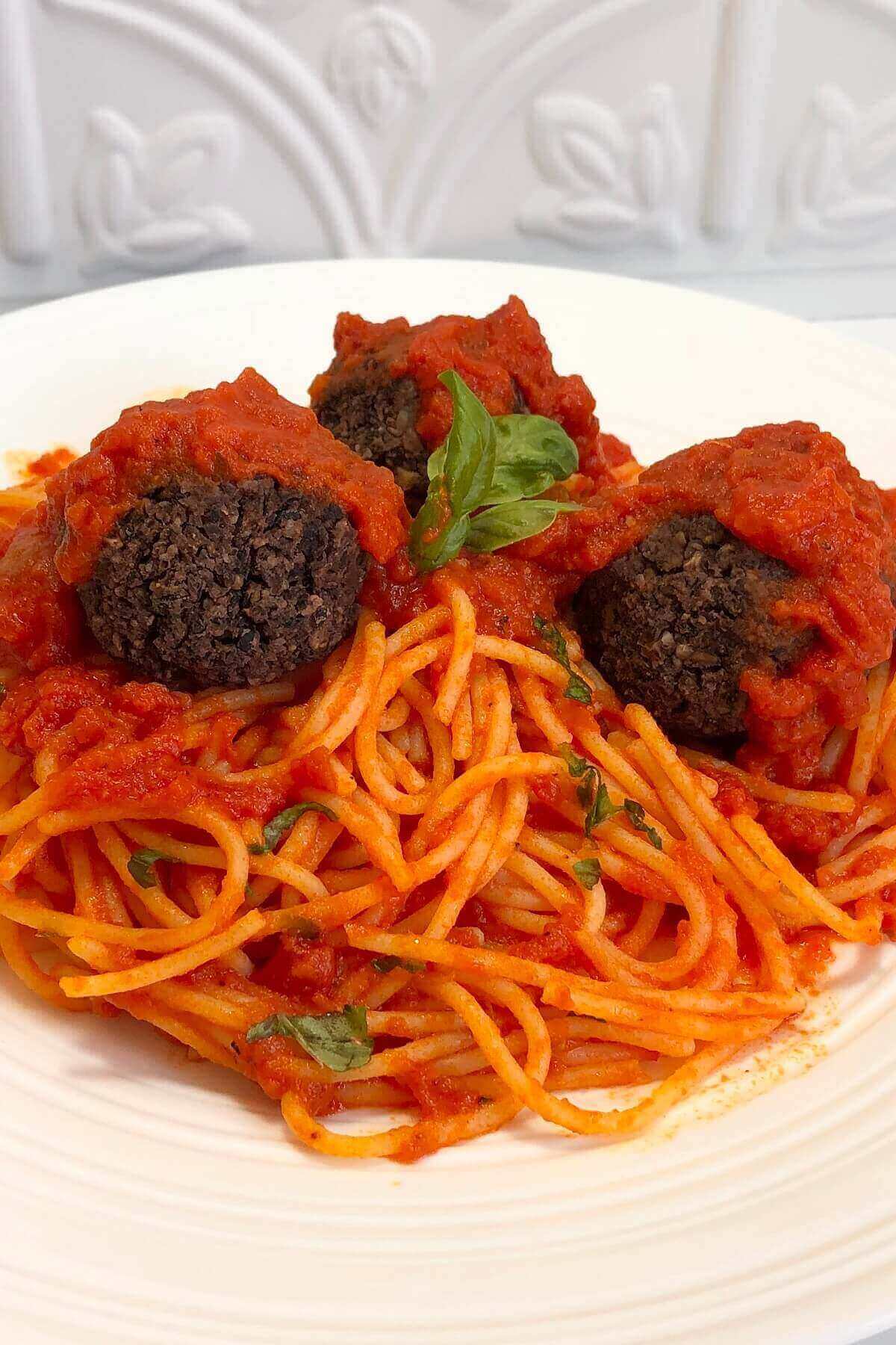 Meatballs and spaghetti with tomato sauce on a plate.