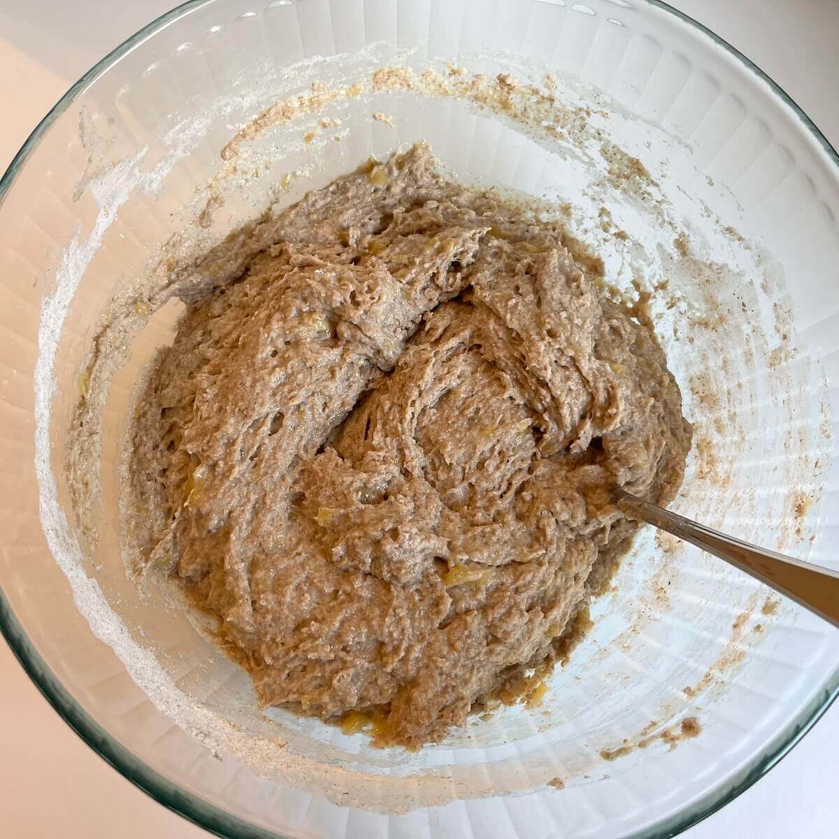 Banana muffin batter in a large glass bowl.