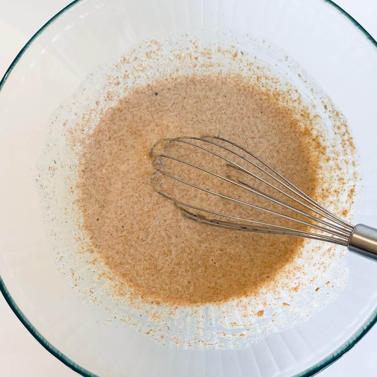 Batter for cauliflower in a large glass bowl.