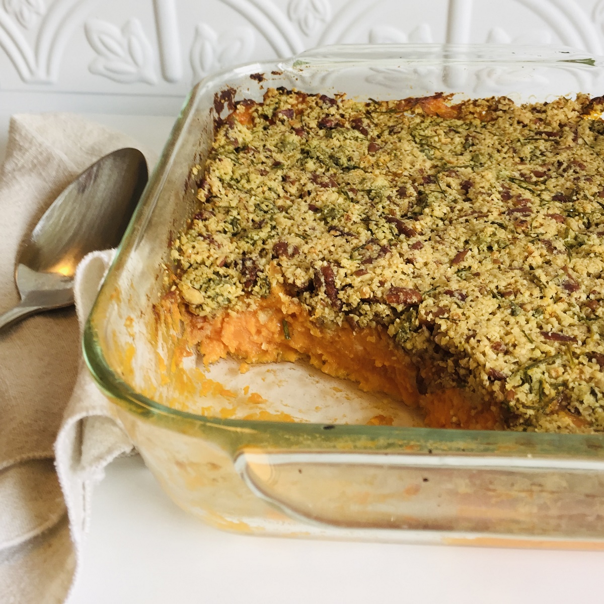 Savory vegan sweet potato casserole in a square glass baking dish.