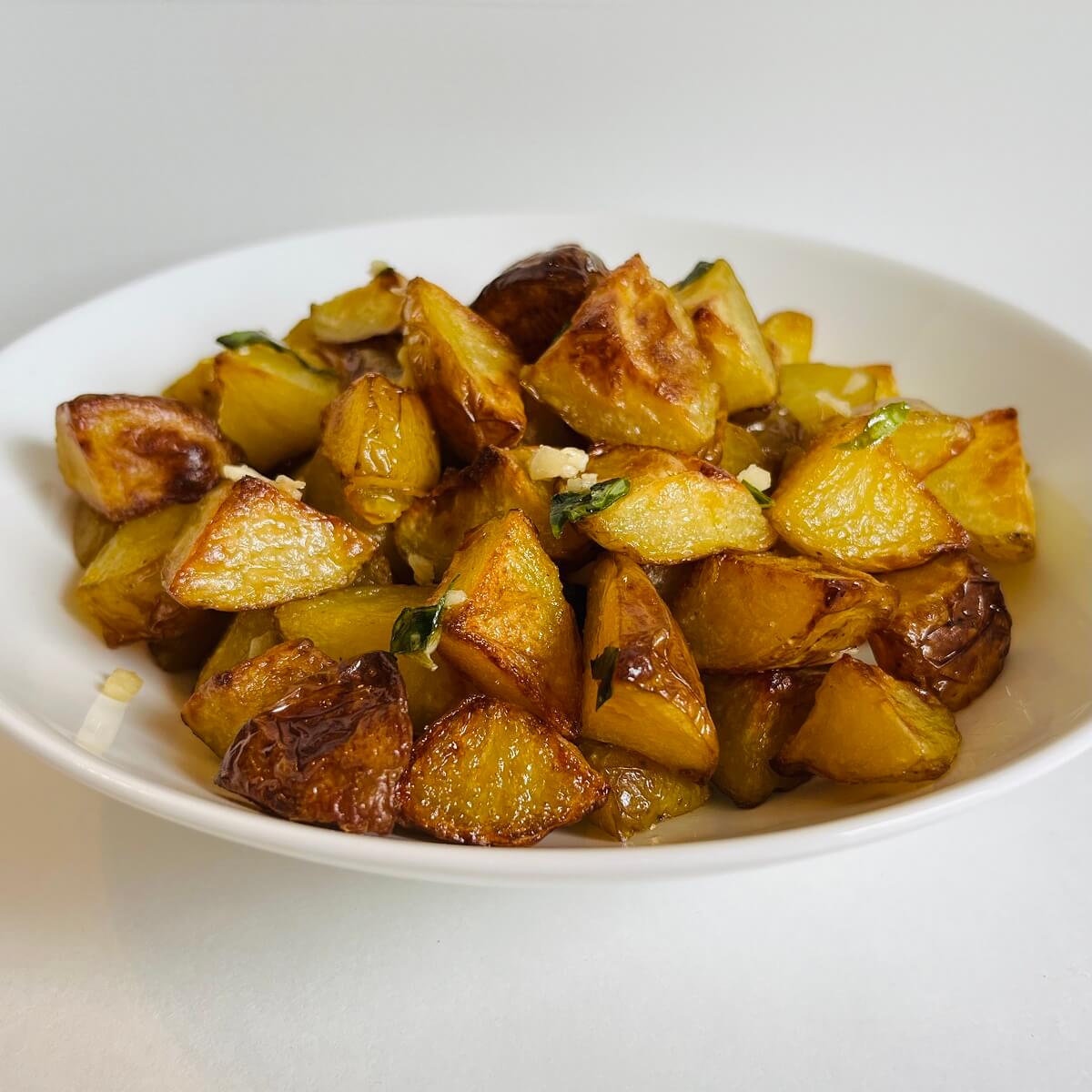 A bowl full of roasted potatoes.