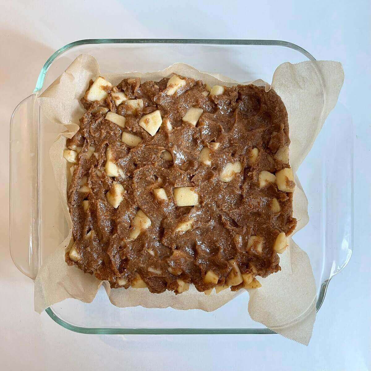 Raw apple squares in a glass baking pan.