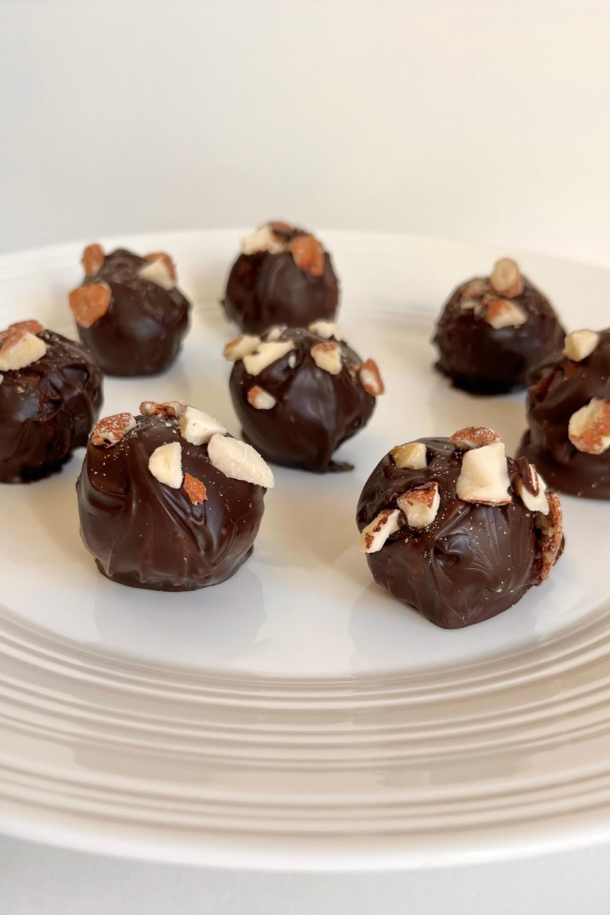 Chocolate almond treats on a white plate.