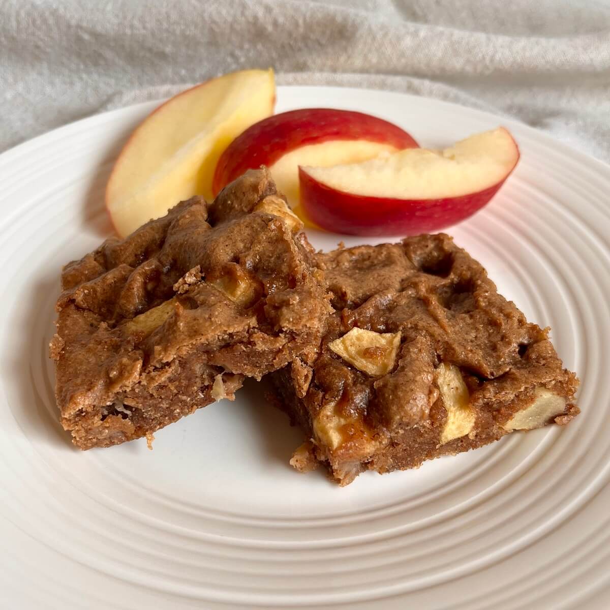 Two vegan apple bars on a white plate.