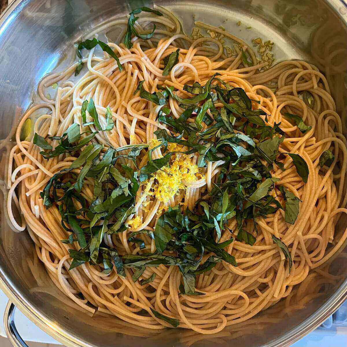 Ingredients for a pasta dish in a metal pot.