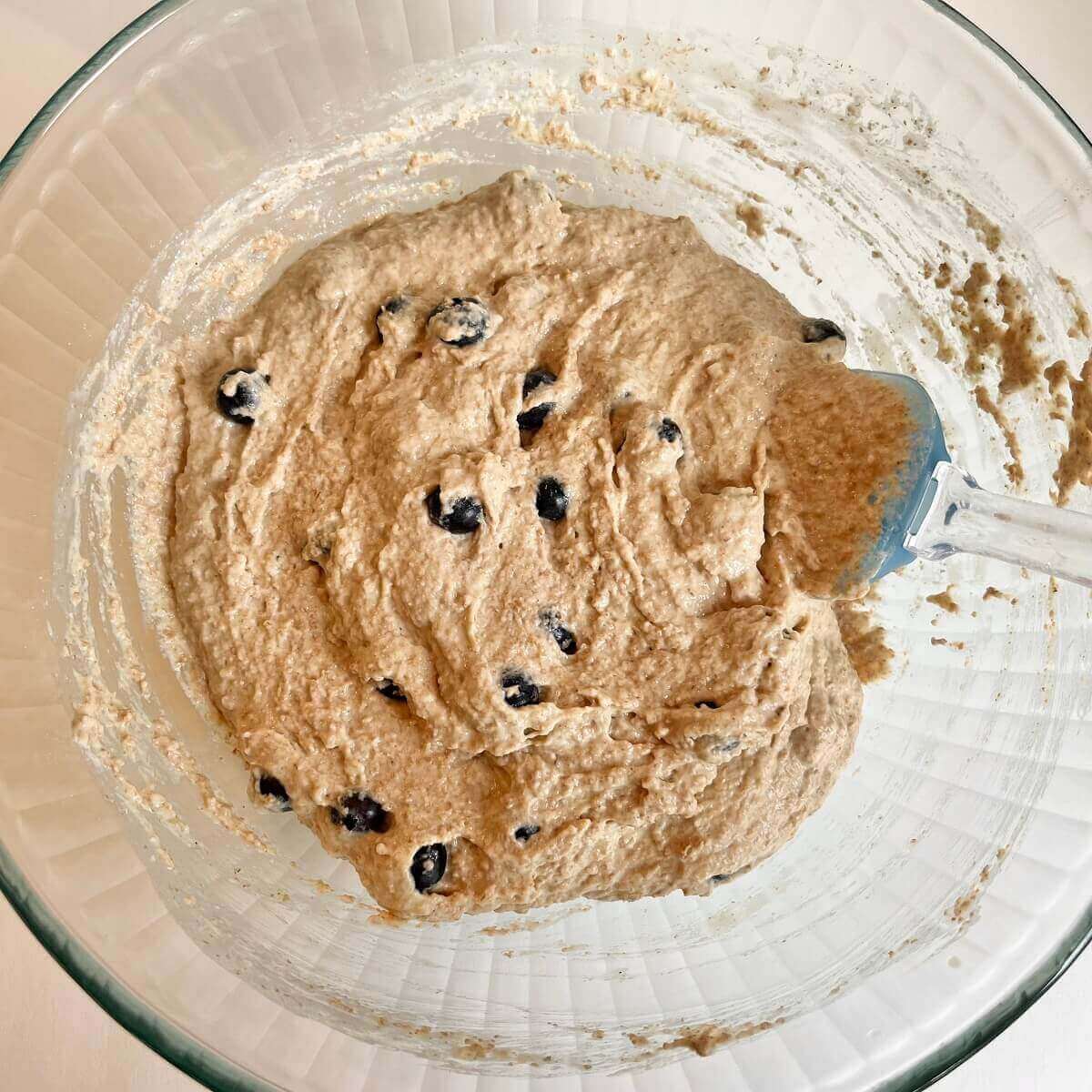 Blueberry cake batter in a glass mixing bowl.