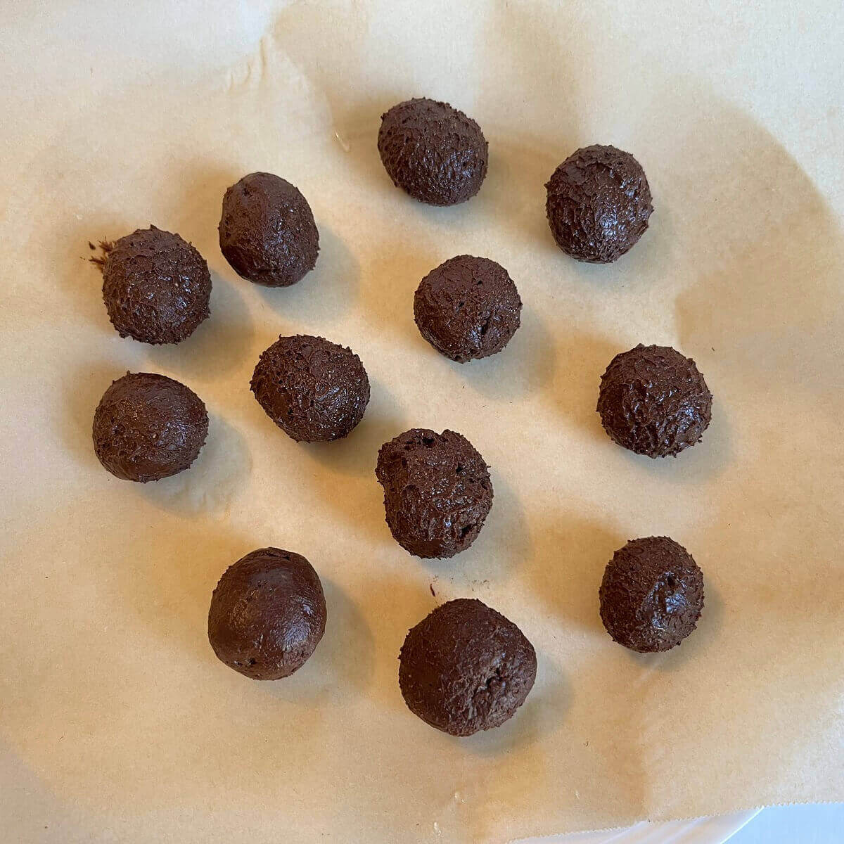 Chocolate almond butter balls on parchment paper.