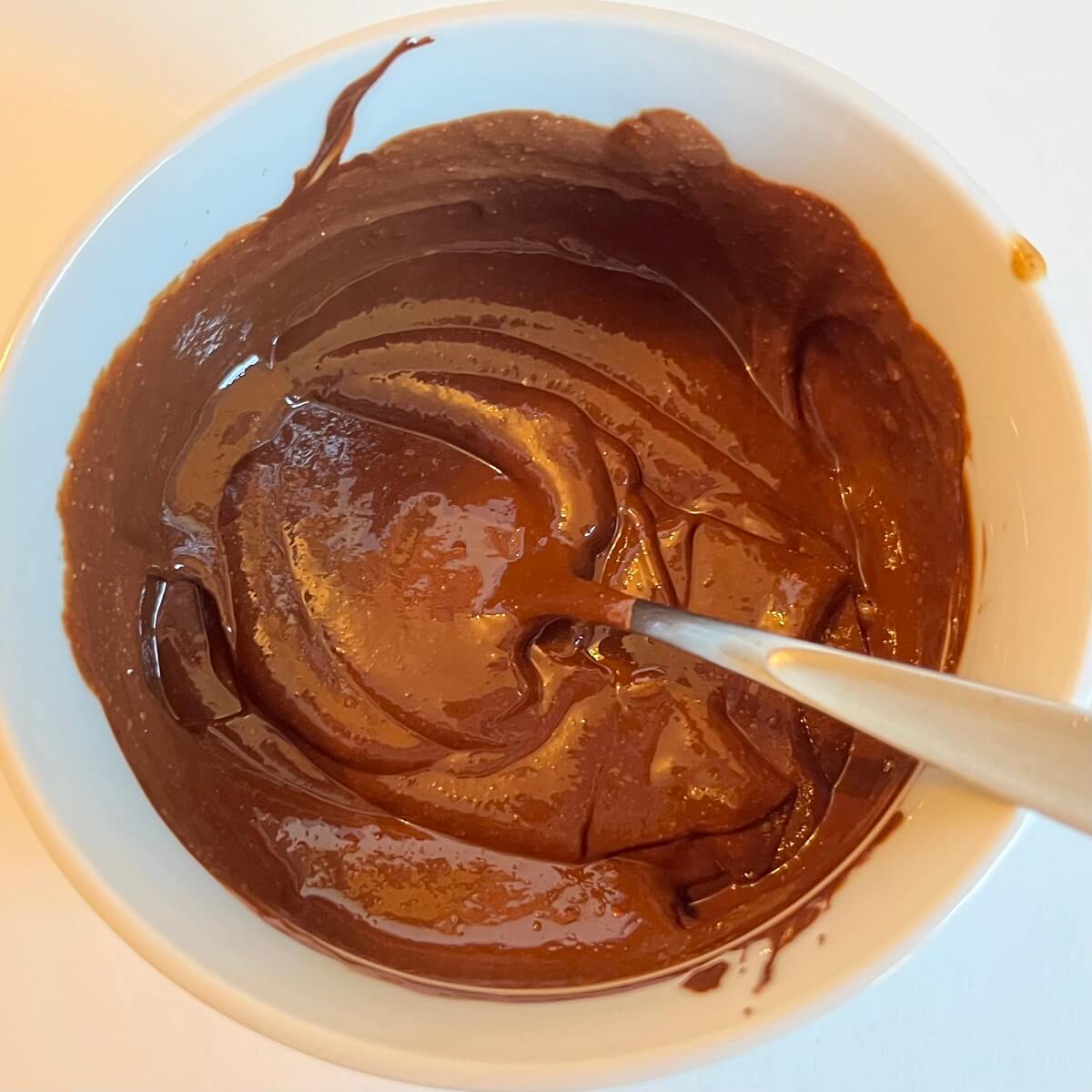 Chocolate mixed with almond butter in a white bowl.