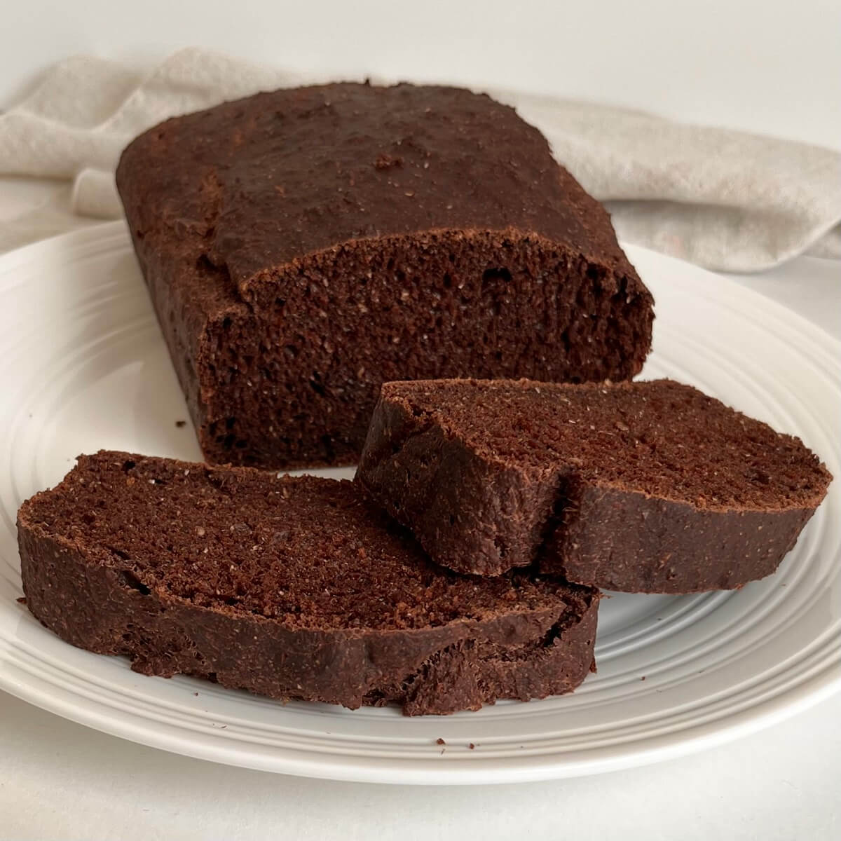 A loaf of no-knead chocolate bread with two thick slices cut.
