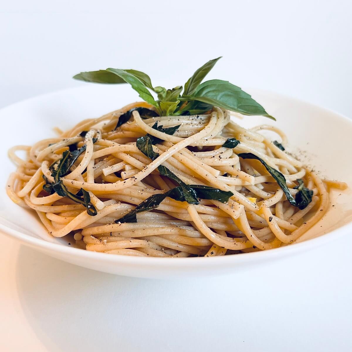 A serving of lemon basil pasta in a white bowl.