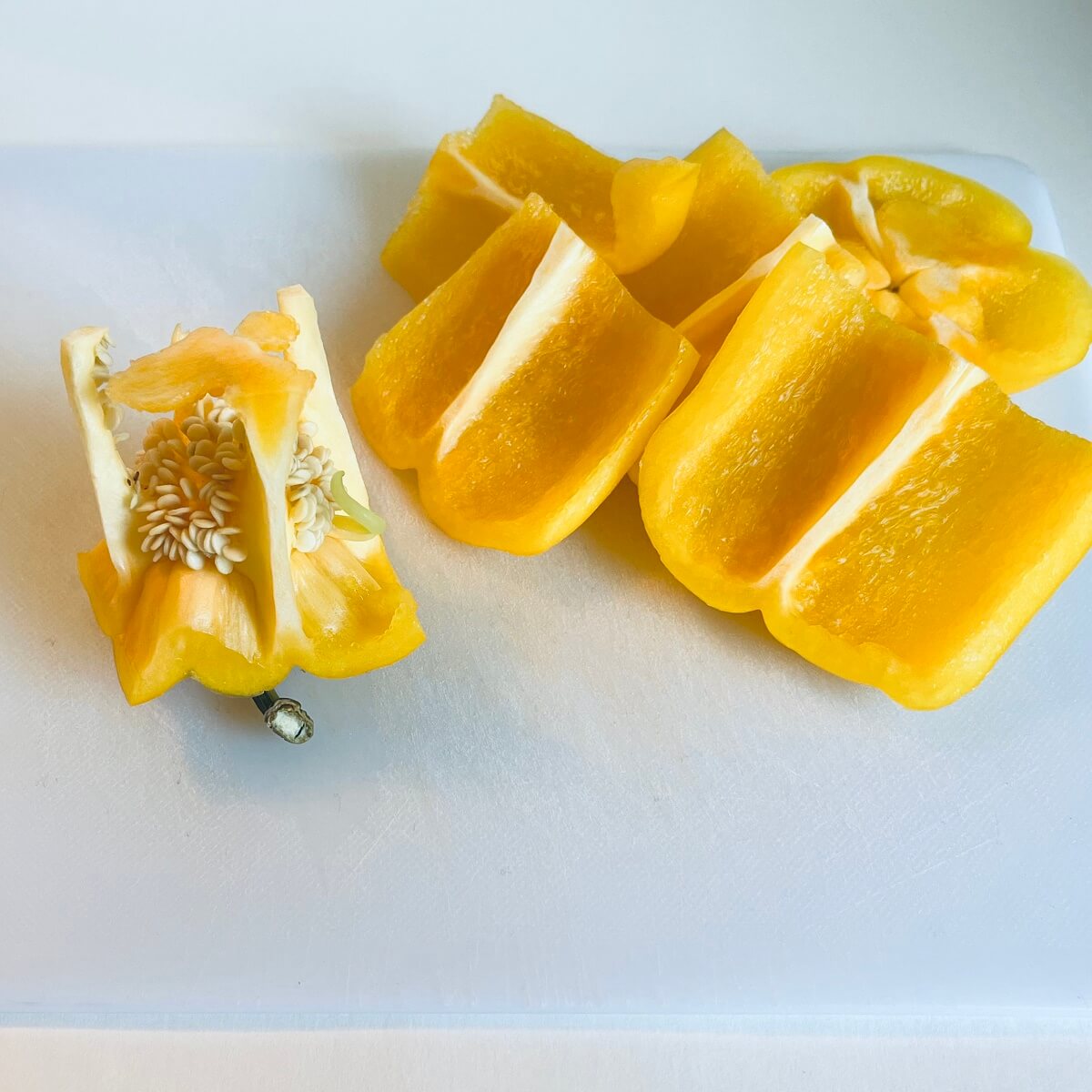 Yellow pepper slices on a cutting board.