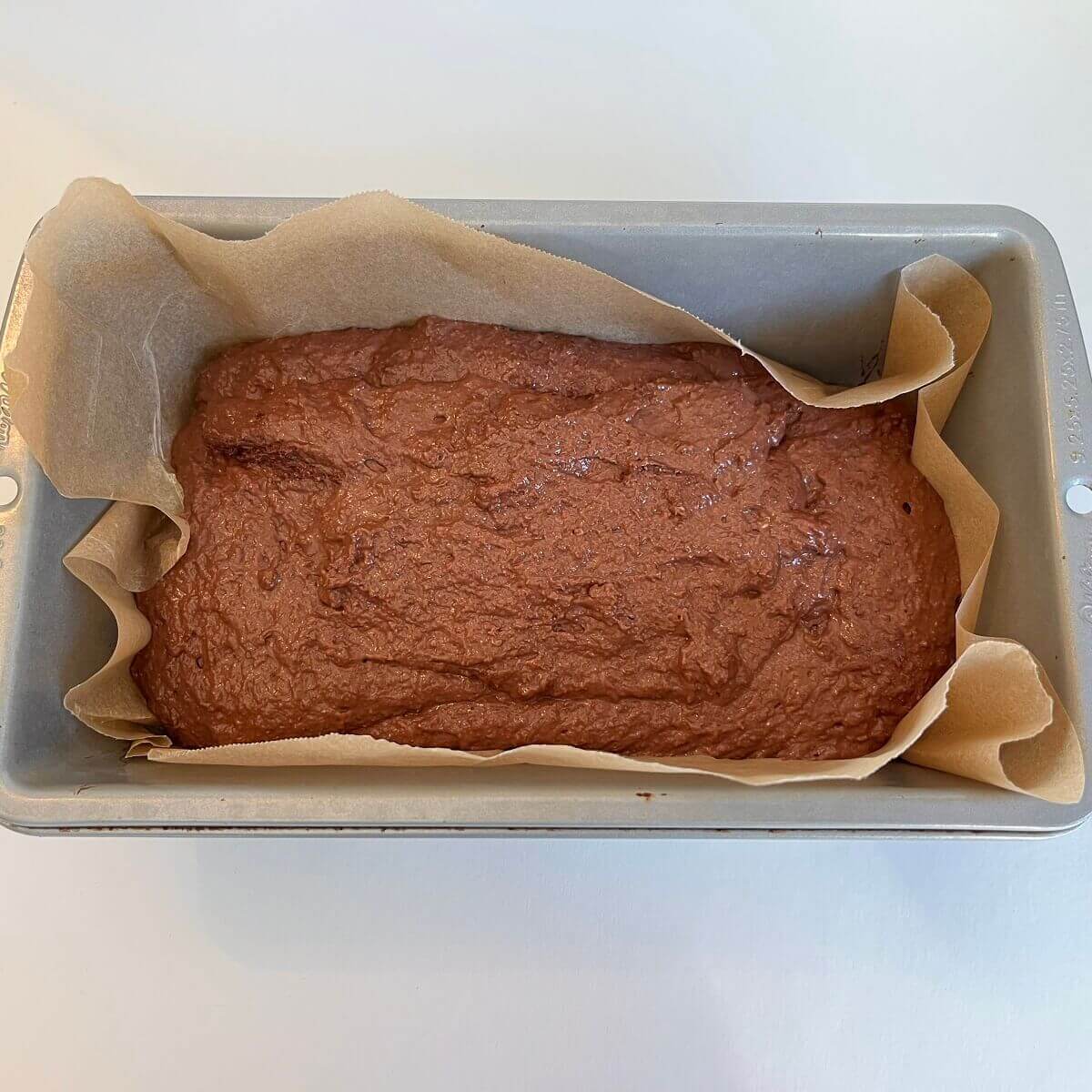 Raw bread dough in a metal pan.