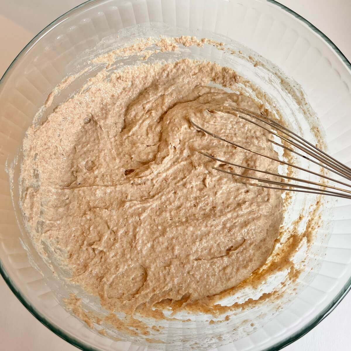 Raw cake batter in a large glass bowl.