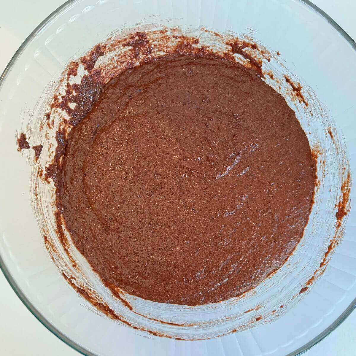 Risen bread dough in a large glass bowl.