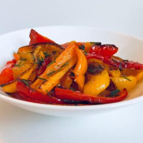 Roasted peppers in a white bowl.