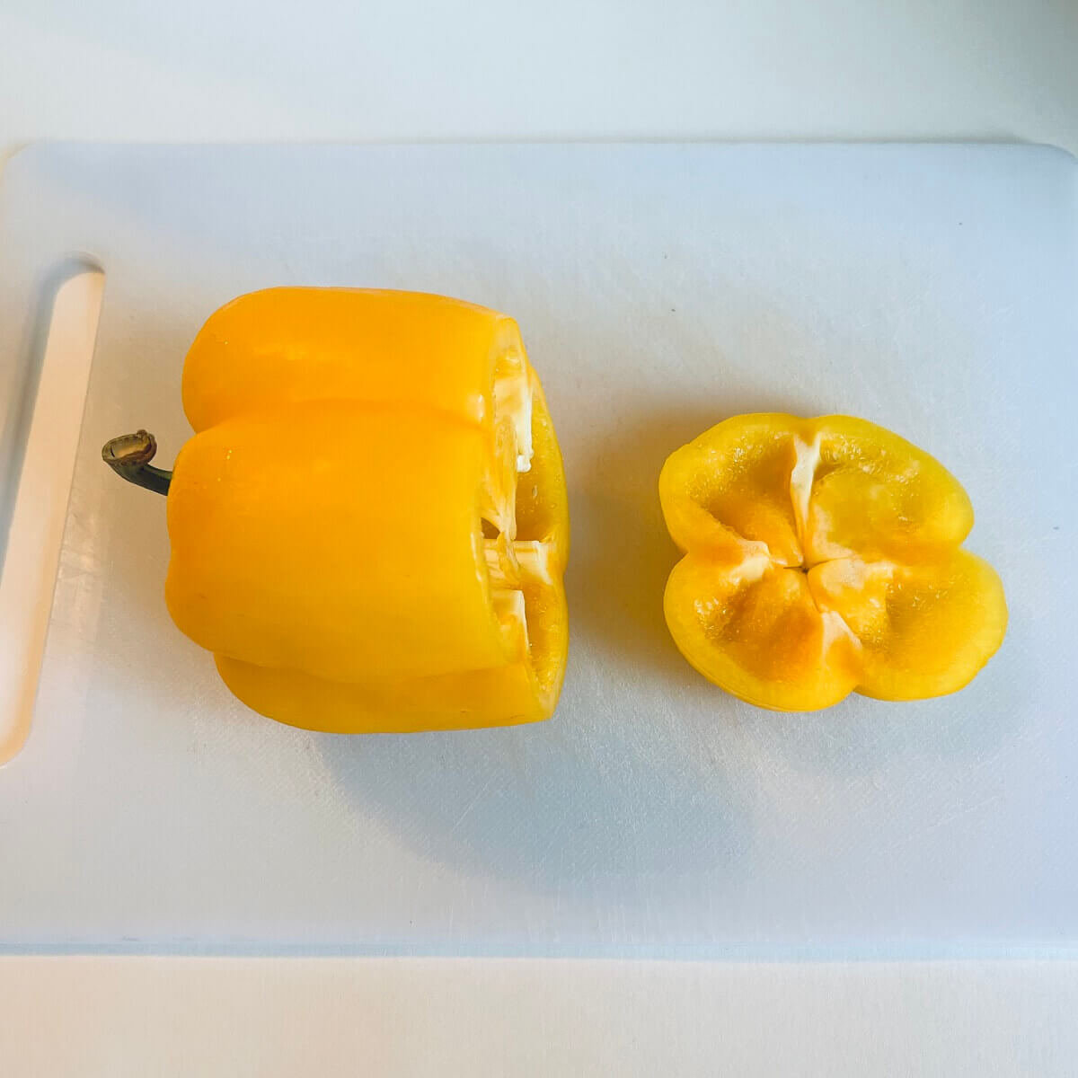 A yellow bell pepper with the bottom end cut off.