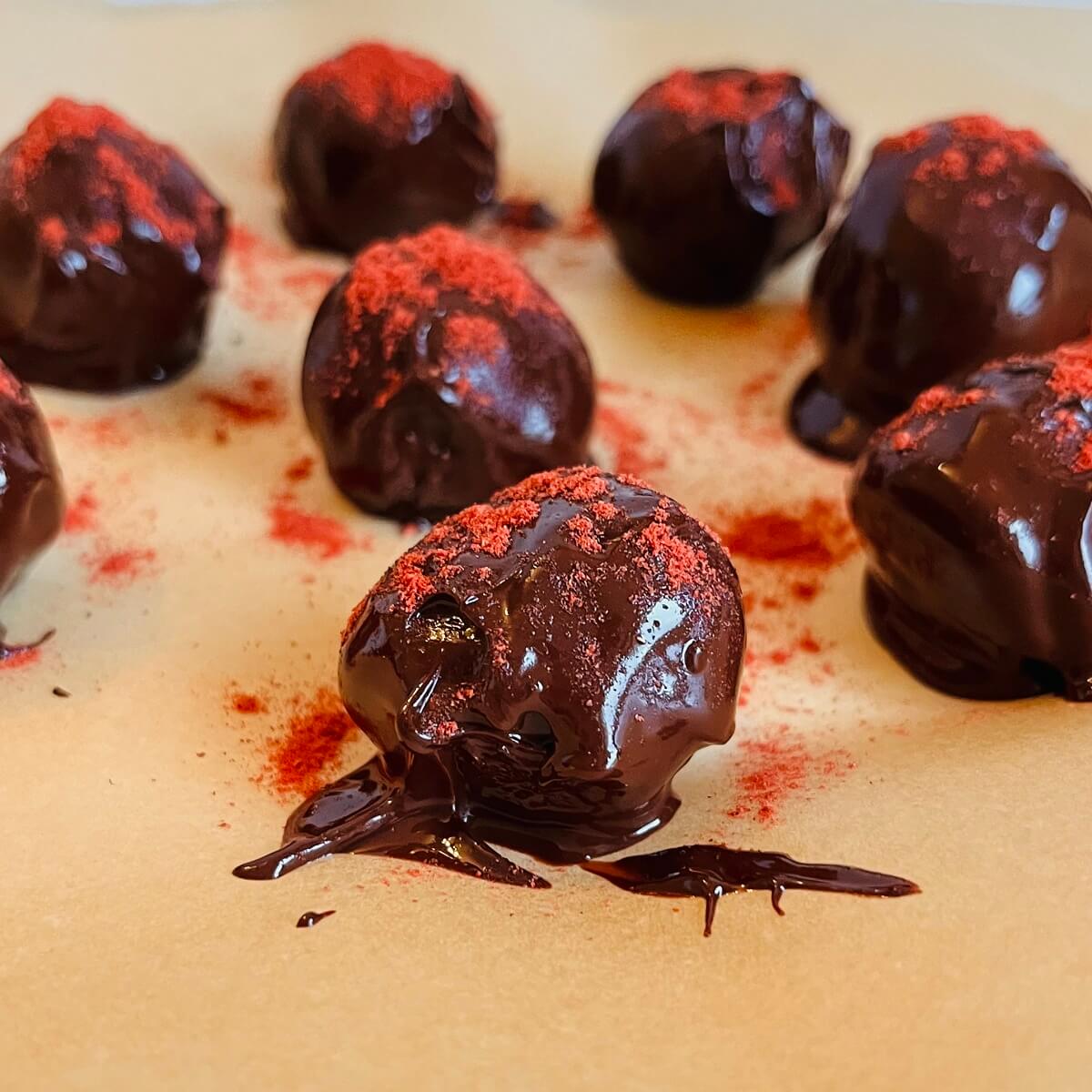 Chocolates with freeze-dried strawberry powder sprinkled on top.