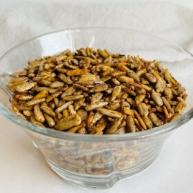 A glass bowl filled with sunflower seeds.