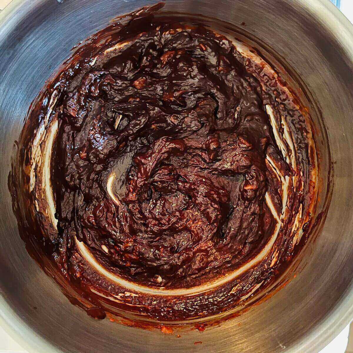 A mixture of strawberries and melted chocolate in a metal pot.