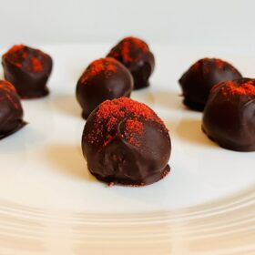 Strawberry truffles on a white plate.