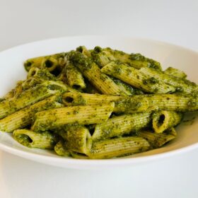 A bowl of pasta in a green sauce.
