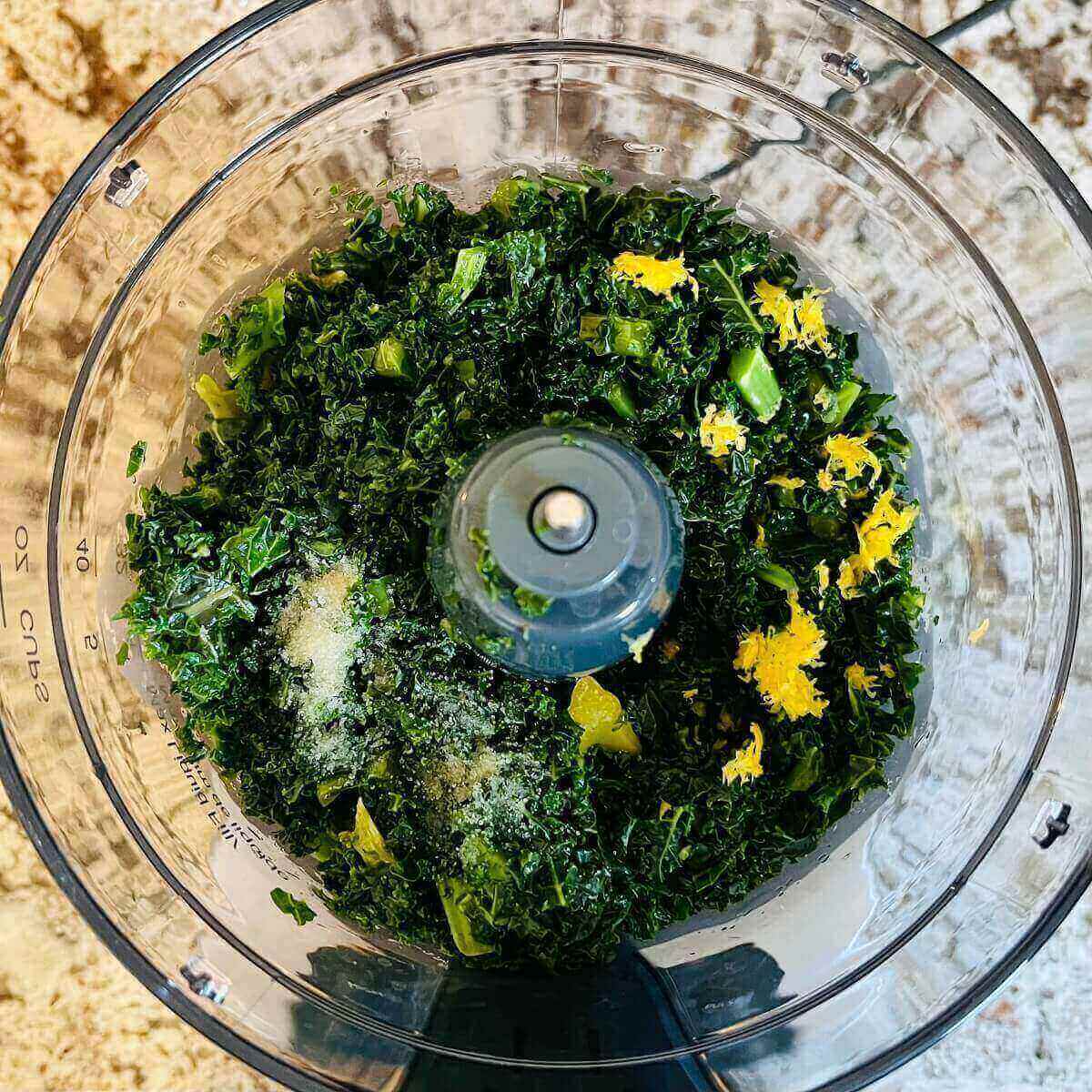 Ingredients for kale sauce in a food processor.