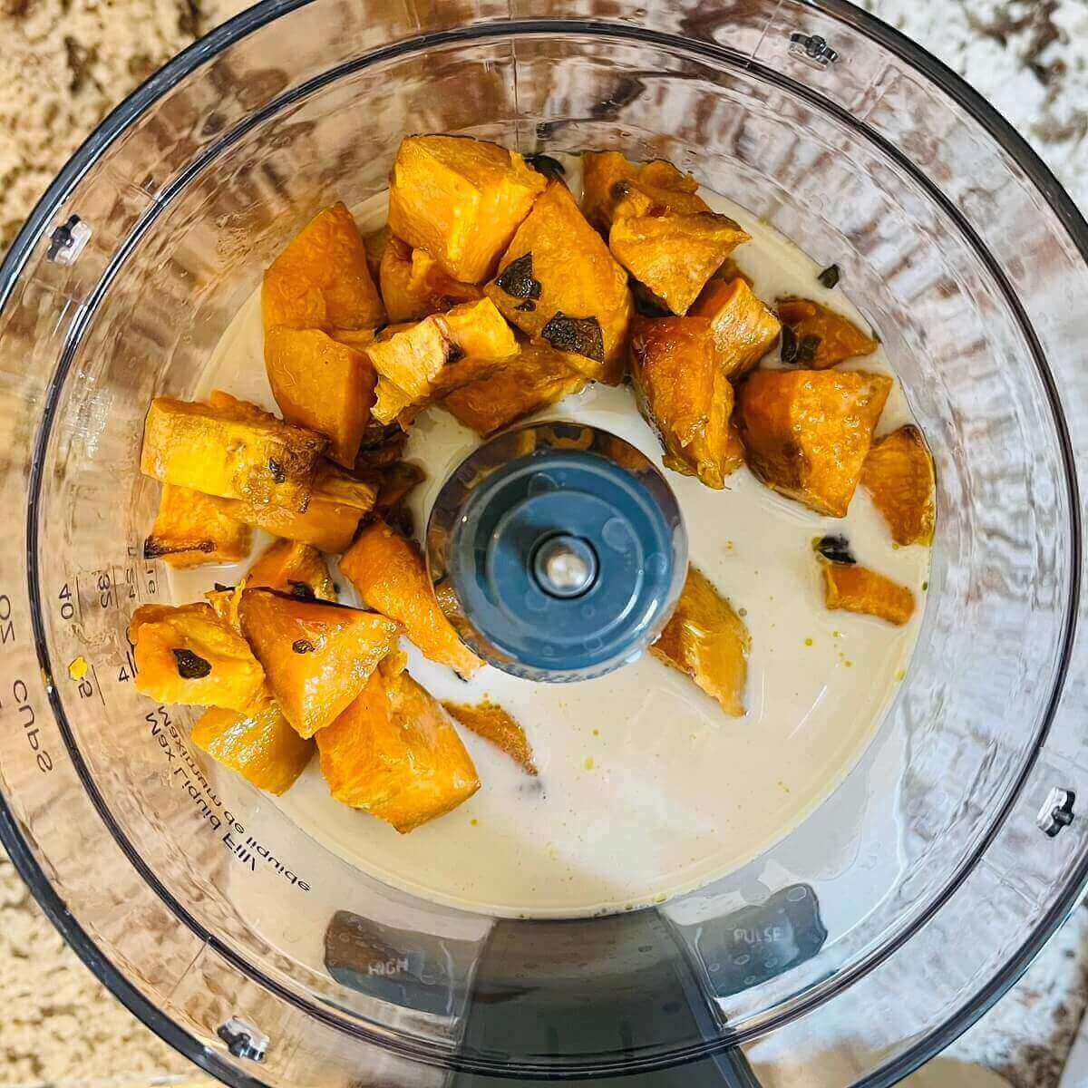 Ingredients for sweet potato sauce in a food processor.