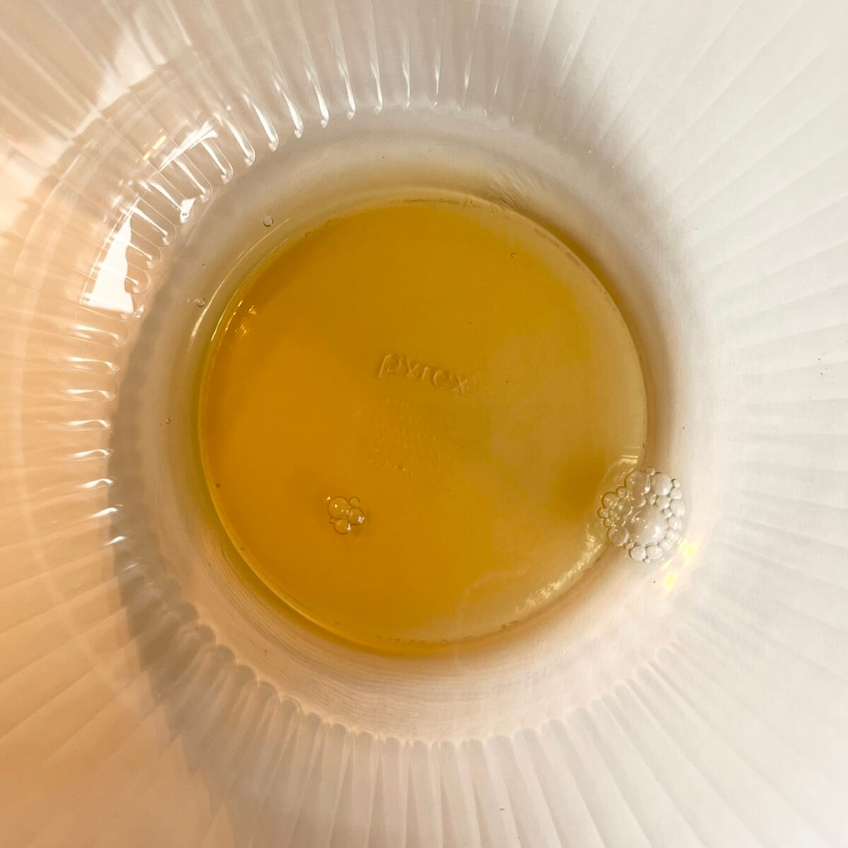 Pale brown transparent liquid in a glass bowl.