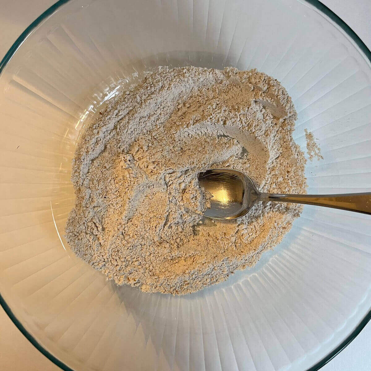 Dry ingredients for cookies in a glass mixing bowl.
