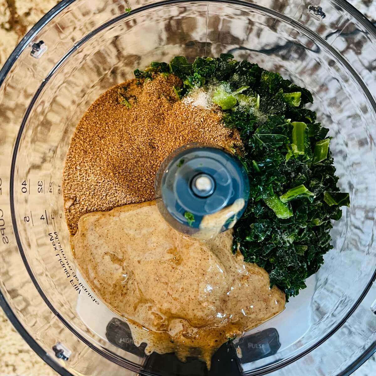 Kale, almond butter, coconut sugar, and other ingredients in a food processor.