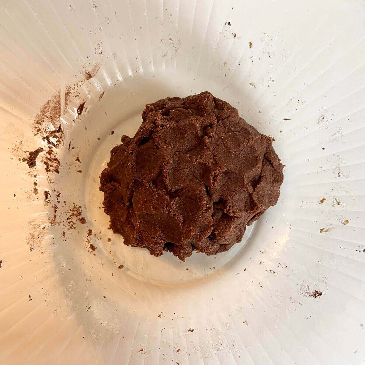 Brown cookie dough in a large glass bowl.