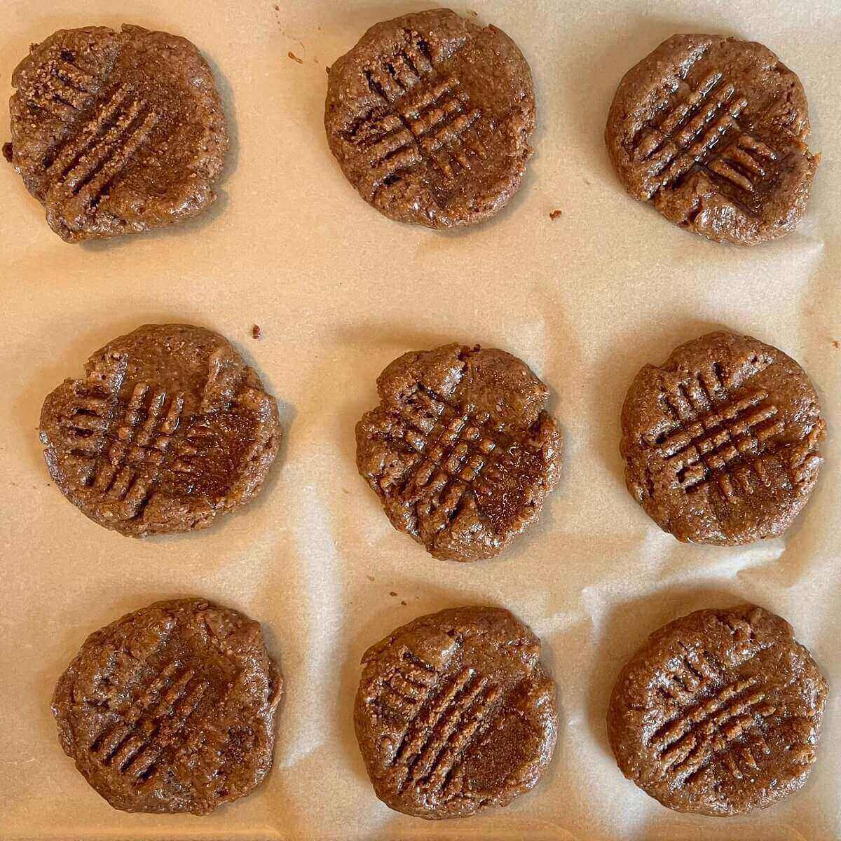 Raw almond cookies on a baking sheet lined with parchment paper,