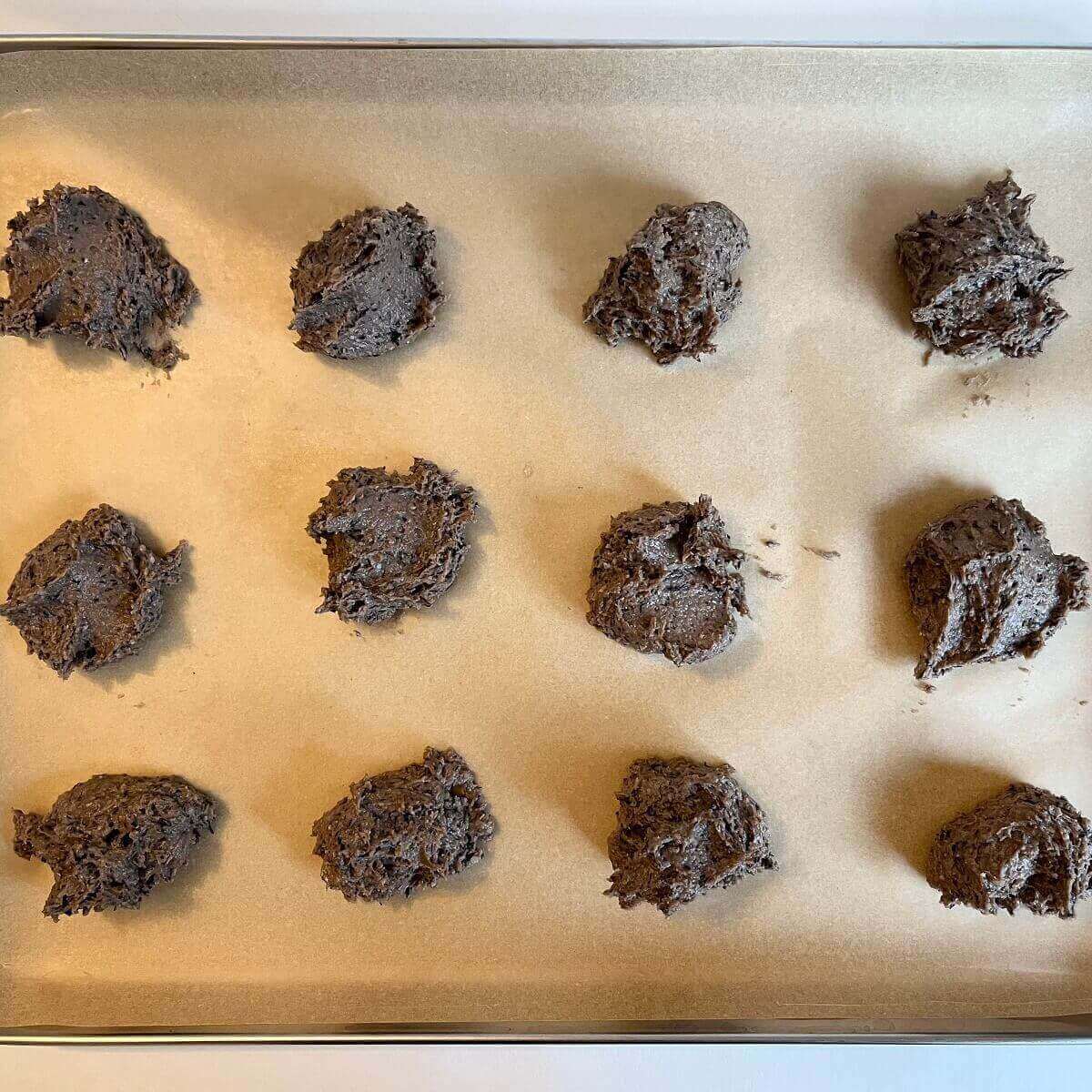 Raw blueberry cookies on a sheet pan lined with parchment paper.