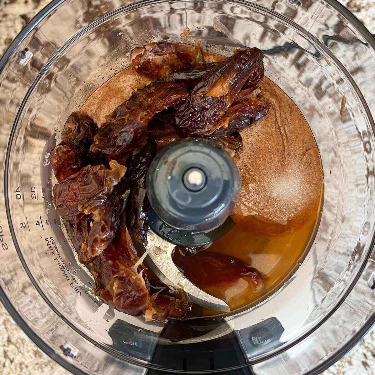 Dates, almond butter, and other ingredients in a food processor.